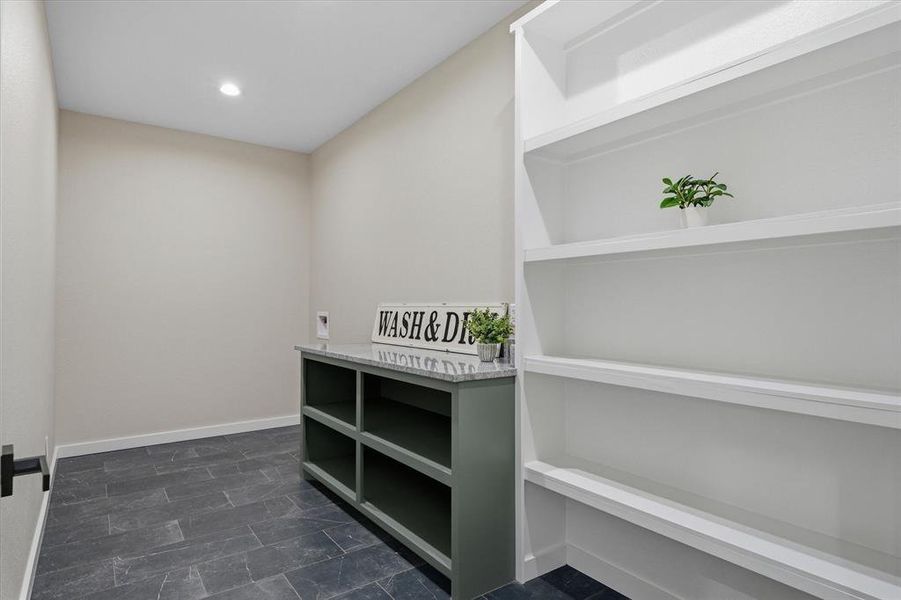 Large laundry room with extra shelves for pantry space or storage.