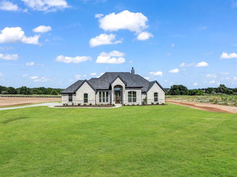 French country style house with stone siding, a front lawn, and a chimney French country style house with stone siding, a front lawn, and a chimney
