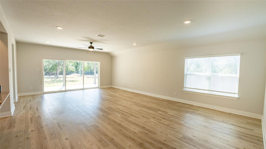 Spare room with healthy amount of natural light, light wood finished floors, a ceiling fan, and recessed lighting Spare room with healthy amount of natural light, light wood finished floors, a ceiling fan, and recessed lighting