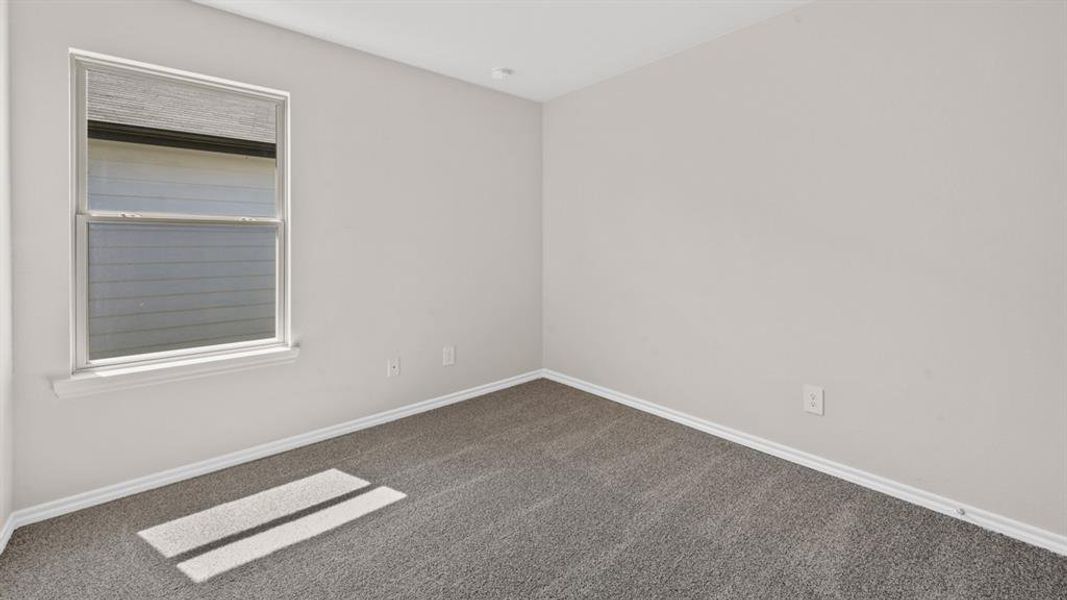 Bedroom featuring light gray wall paint, gray carpeting, white trim, and a double-pane window