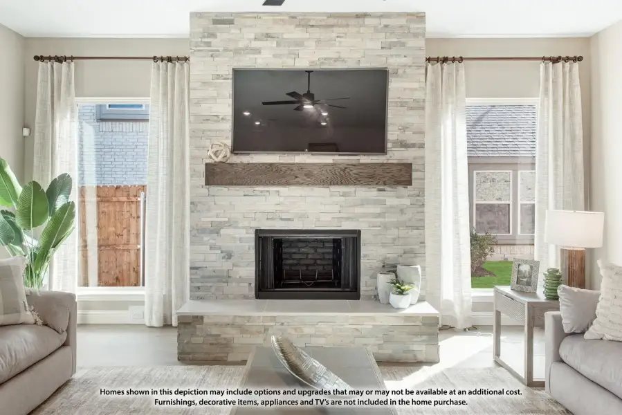 Living room with floor-to-ceiling stacked stone fireplace, wood mantel, and wall-mounted TV between two windows