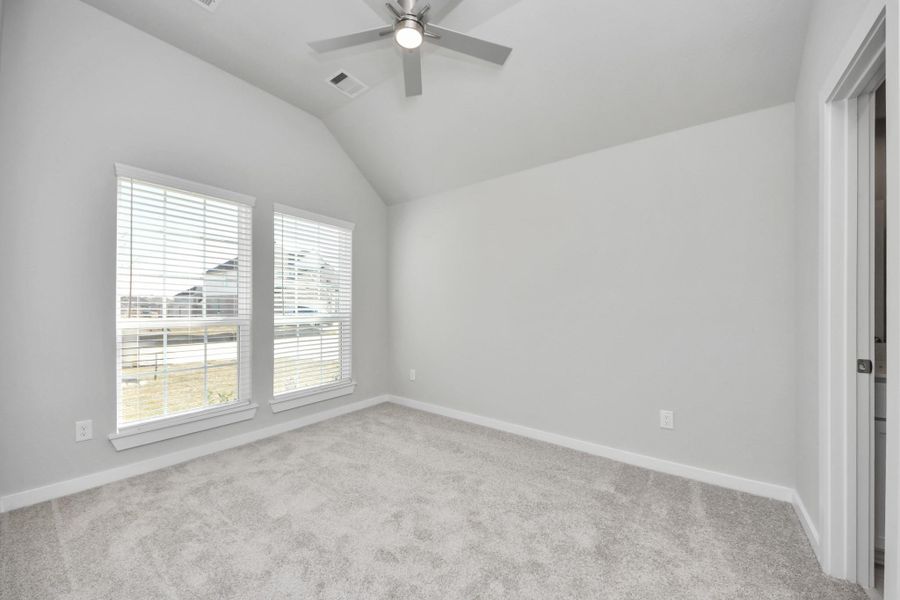 Secondary bedroom features plush carpeting, large windows that let in plenty of natural light, bright paint, and spacious closets. Sample photo of completed home with similar floor plan. Actual colors and selections may vary.