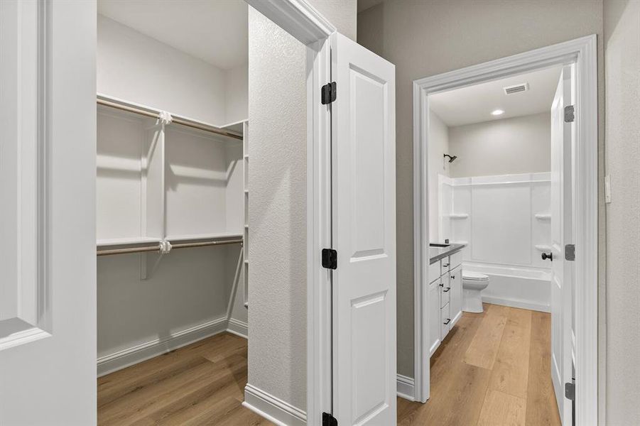Spacious closet with light wood-style floors Spacious closet with light wood-style floors