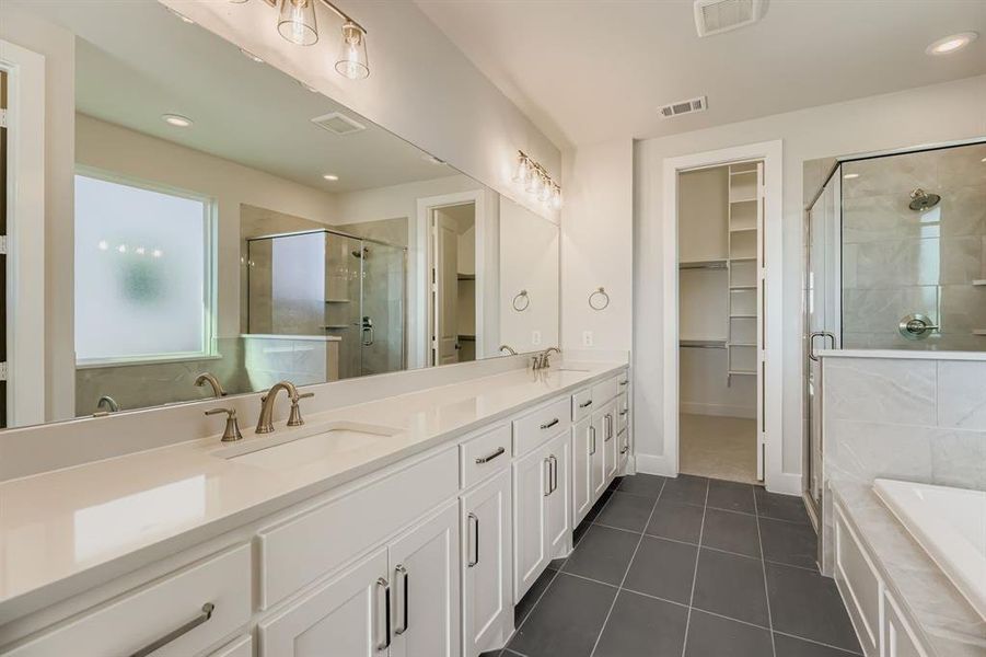Full bath with a spacious closet, double vanity, a bath, a stall shower, and recessed lighting