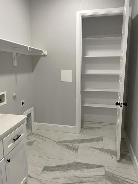 Laundry area with built-in linen closet