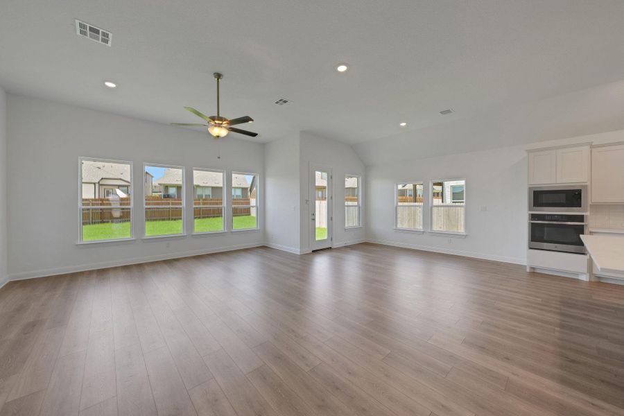 Unfurnished living room featuring recessed lighting, a ceiling fan, wood finished floors, and lofted ceiling