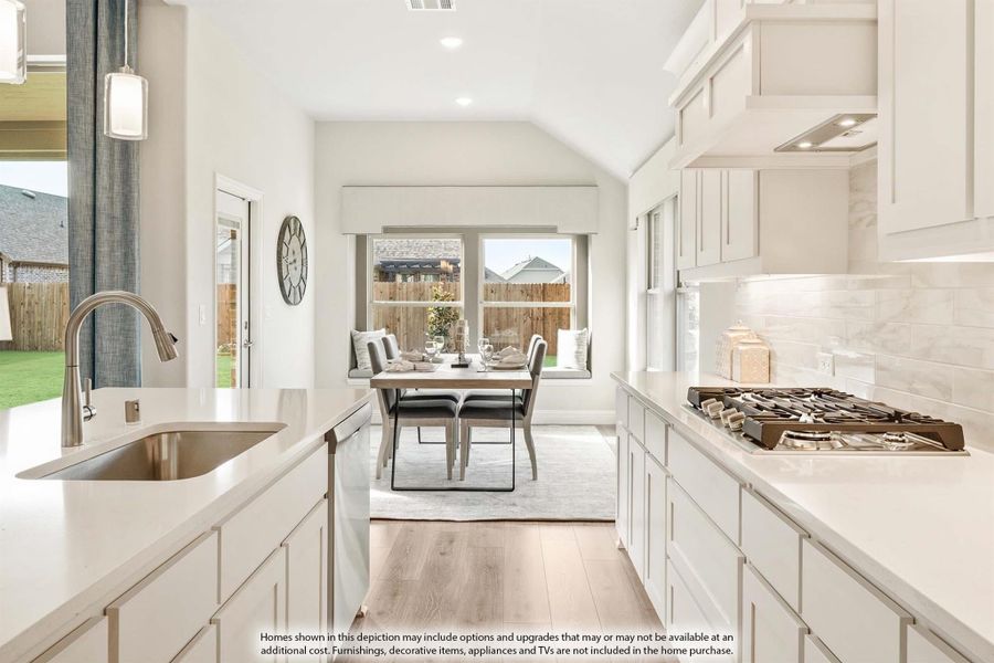 White kitchen with quartz countertops, gas cooktop, and farmhouse sink opening to a bright dining nook with vaulted ceiling