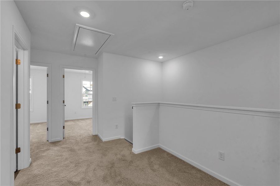 This bright, carpeted hallway offers a blank canva