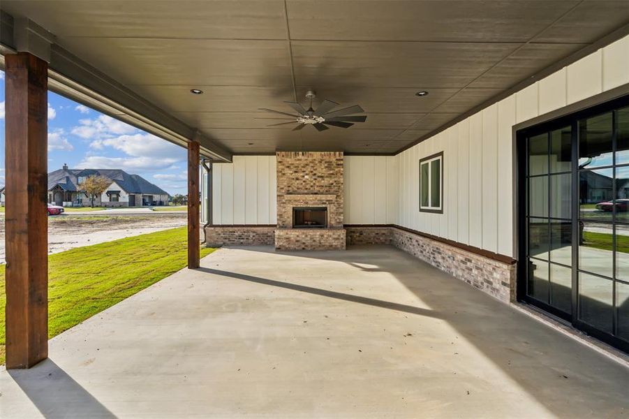 View of patio / terrace featuring ceiling fan and an outdoor brick fireplace