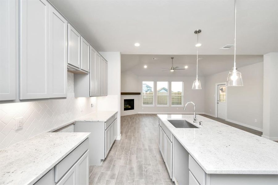 Discover another perspective of this stunning kitchen, generously appointed with an abundance of counter space. Sample photo of completed home with similar floor plan. As-built interior colors and selections may vary.