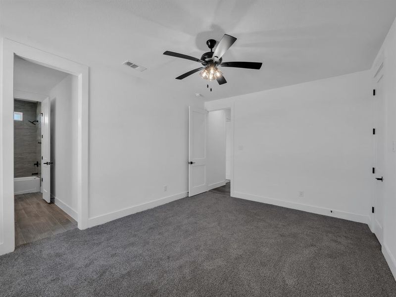 Spare room with dark carpet and ceiling fan