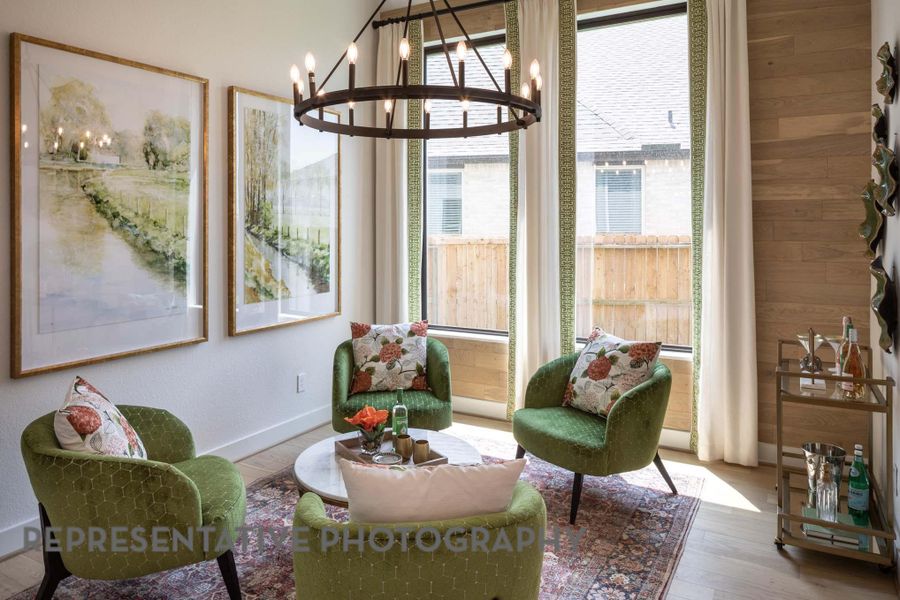 Living area with baseboards, a notable chandelier, and wood finished floors Living area with baseboards, a notable chandelier, and wood finished floors