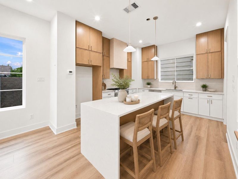 Gourmet kitchen features a large waterfall island with quartz countertops.