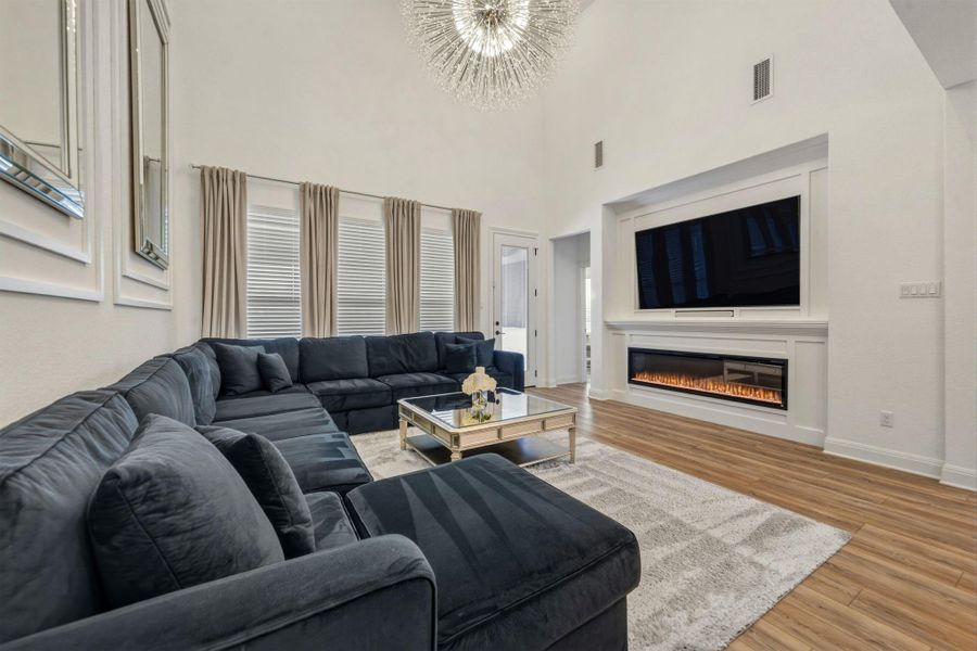 Spacious living area featuring high ceilings and multiple windows with blinds