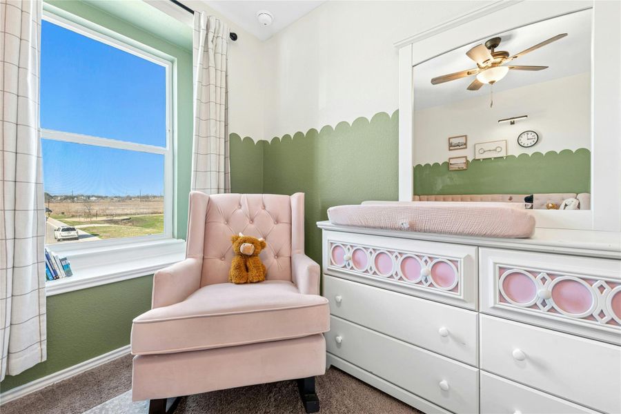 Sitting room with a ceiling fan and carpet