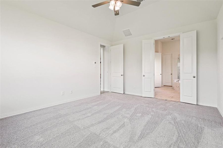 Unfurnished bedroom with light carpet, high vaulted ceiling, and ceiling fan