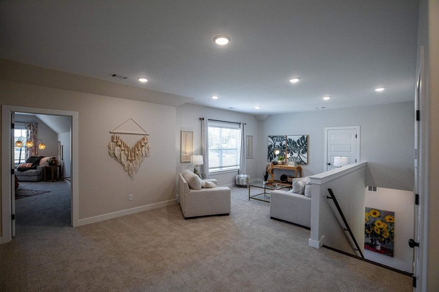 Carpeted loft area featuring recessed lighting, a window with blinds, and white painted trim