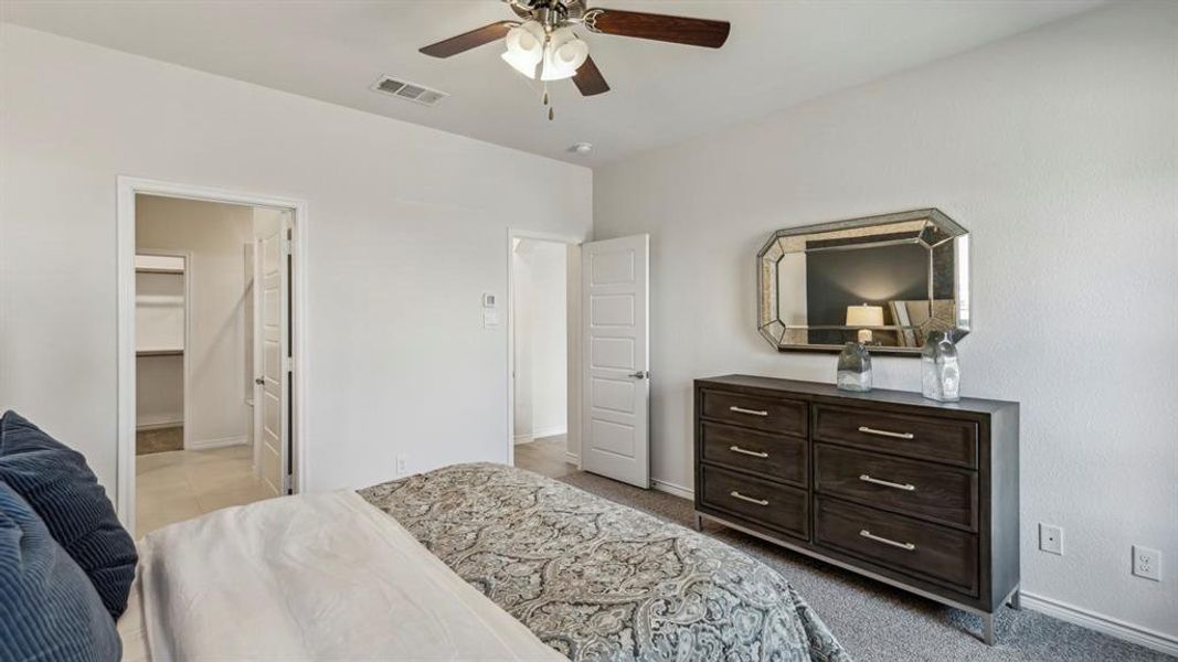 Bedroom featuring carpeted flooring, a ceiling fan, and a walk-in closet