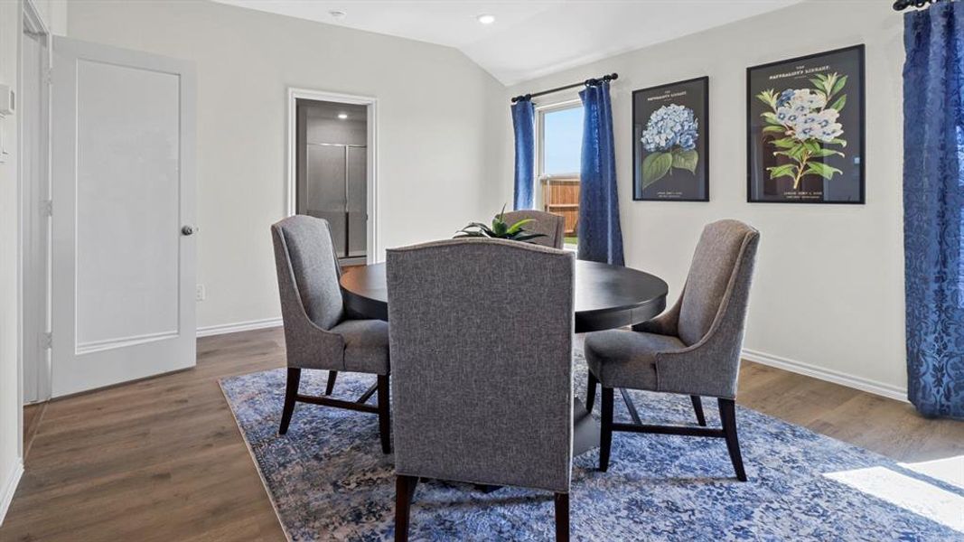 Dining space with wood finished floors, lofted ceiling, and recessed lighting