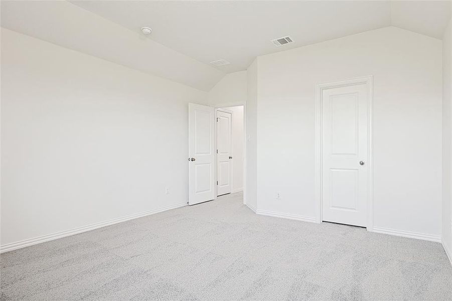 Carpeted spare room with lofted ceiling