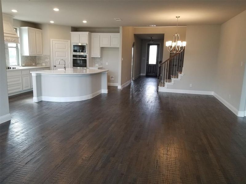 Enormous family room with rich hardwood floors & ceiling fan