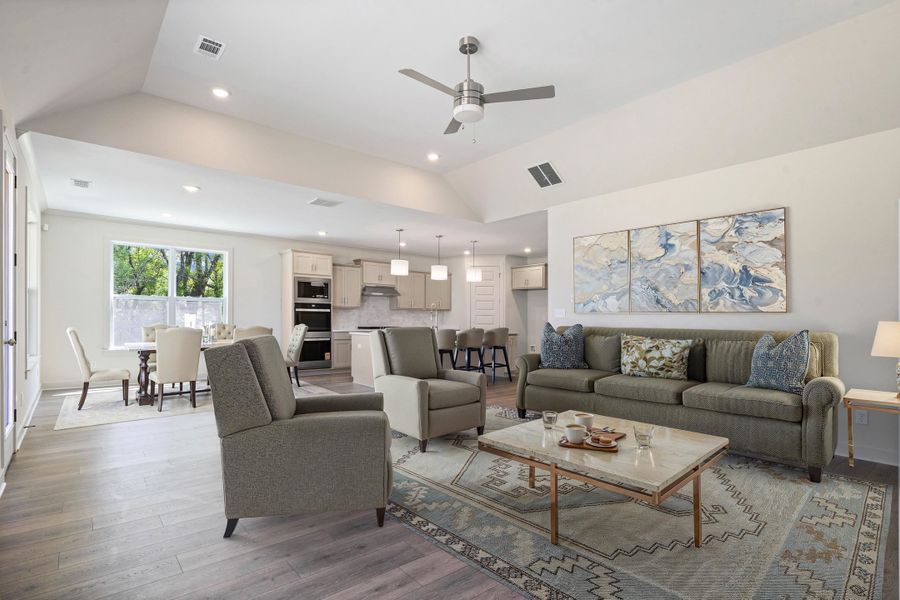 Living room with ceiling fan, wood finished floors, lofted ceiling, and recessed lighting