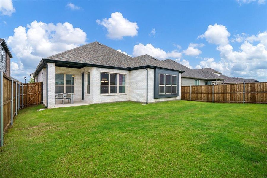 Rear view of house featuring brick siding, a patio area, and a shingled roof Rear view of house featuring brick siding, a patio area, and a shingled roof