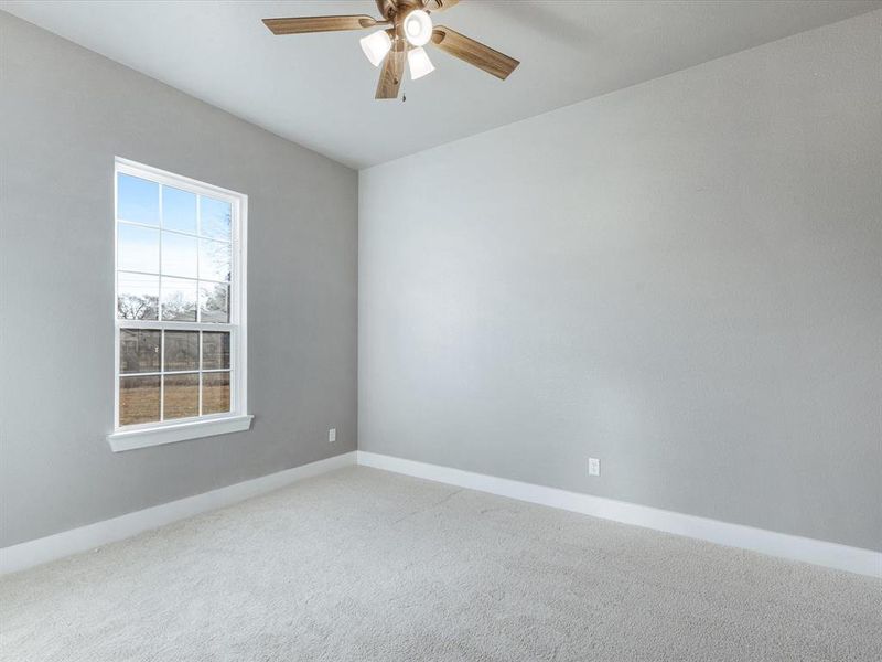 Carpeted spare room featuring a ceiling fan and baseboards Carpeted spare room featuring a ceiling fan and baseboards
