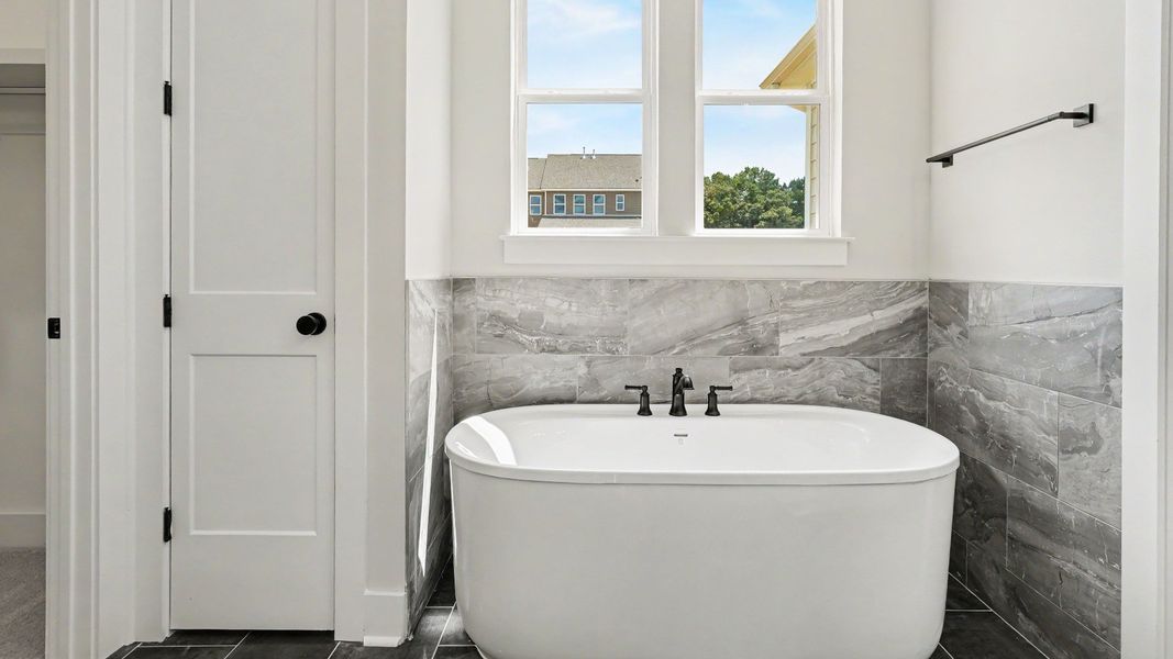 Primary bathroom with dedicated soaking tub and windows Primary bathroom with dedicated soaking tub and windows