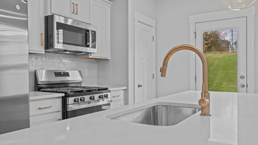 Exceptional kitchen featuring a spacious island, eye-catching pendant lights, and modern finishes Exceptional kitchen featuring a spacious island, eye-catching pendant lights, and modern finishes