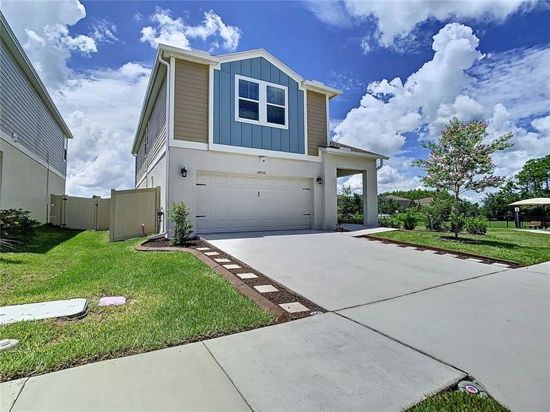 Front exterior of a new home in Pasadena Point, Wesley Chapel, FL, highlighting curb appeal (Image 26). Front exterior of a new home in Pasadena Point, Wesley Chapel, FL, highlighting curb appeal (Image 26).
