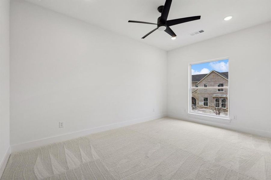 Carpeted empty room with ceiling fan