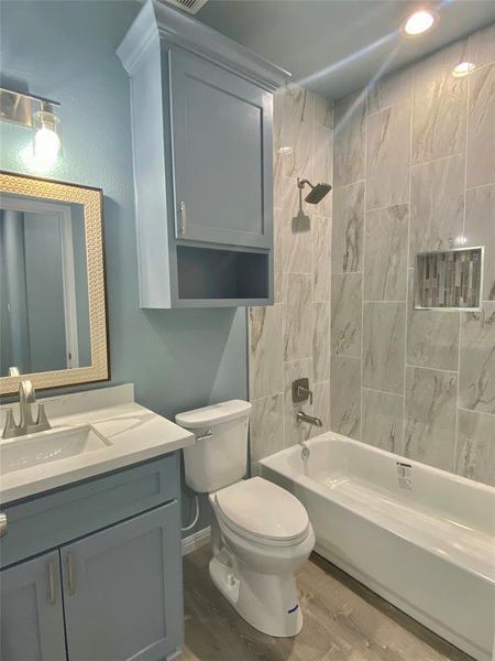 A well-appointed bathroom features a sleek vanity, modern toilet, and a pristine bathtub with a tiled shower surround. A well-appointed bathroom features a sleek vanity, modern toilet, and a pristine bathtub with a tiled shower surround.