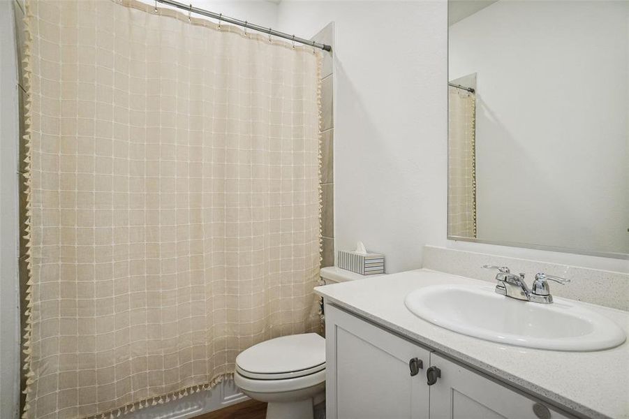 Bathroom with a shower with curtain, vanity, and toilet