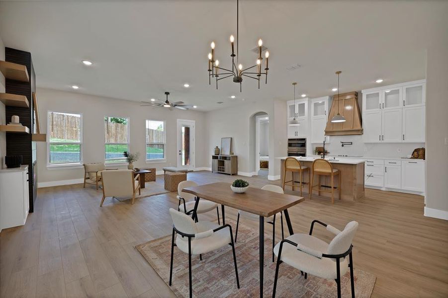 Dining area with light wood-type flooring, baseboards, recessed lighting, arched walkways, and a ceiling fan Dining area with light wood-type flooring, baseboards, recessed lighting, arched walkways, and a ceiling fan