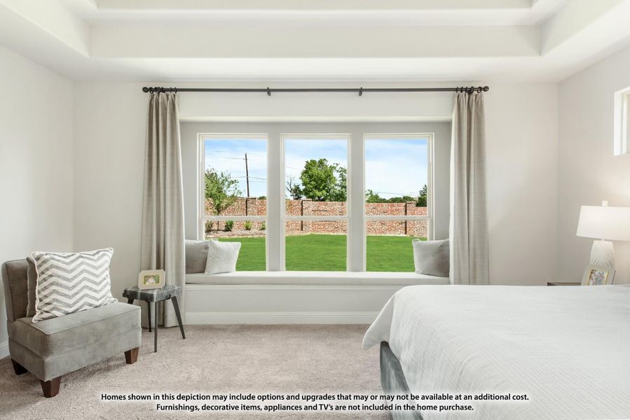 Bedroom with tray ceiling, built-in window seat, triple windows overlooking backyard, and neutral carpet