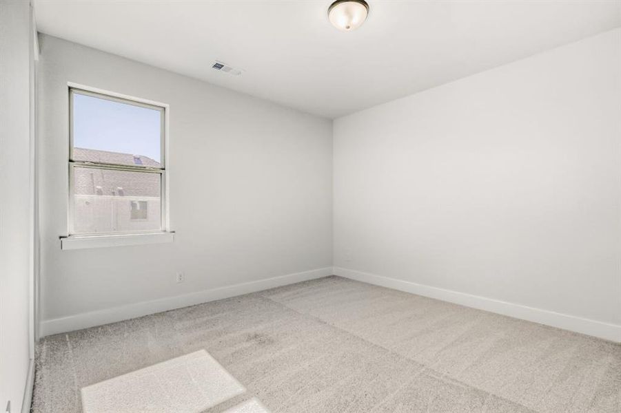 Spare room featuring light colored carpet and baseboards