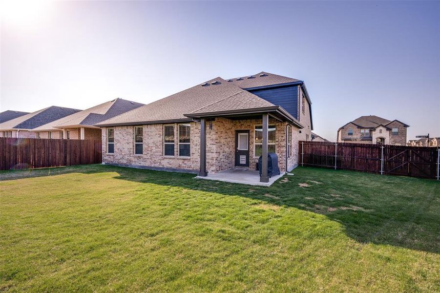 Large fenced in backyard with a covered a patio