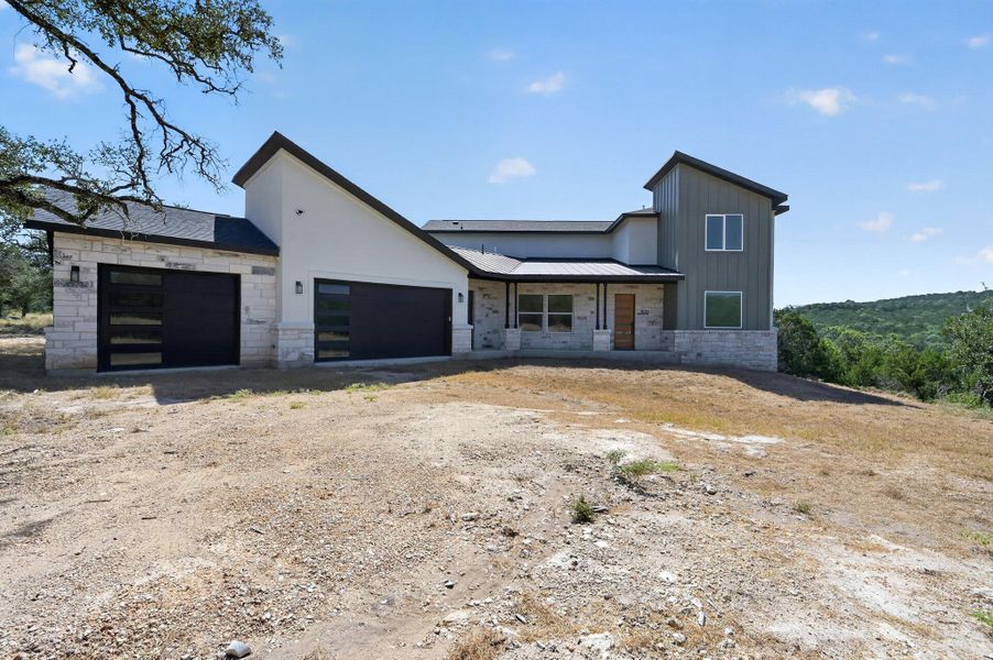 Distinctive modern rooflines and limestone accents define this contemporary hill country exterior.