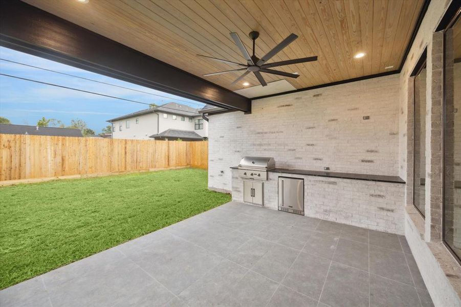 The outdoor kitchen includes a 34-inch Coyote grill for cooking the perfect steak or burger! It also features a beverage cooler and overlooks the spacious backyard.