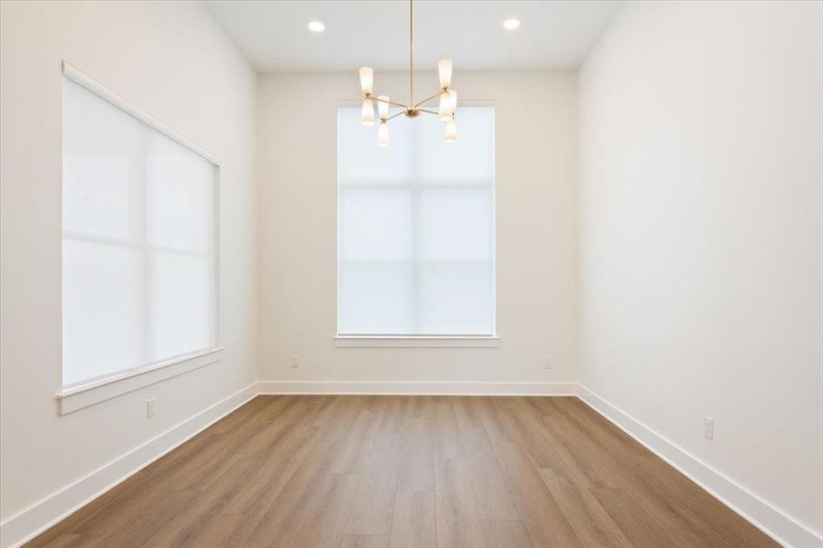 Unfurnished dining area featuring wood finished floors, a chandelier, and recessed lighting