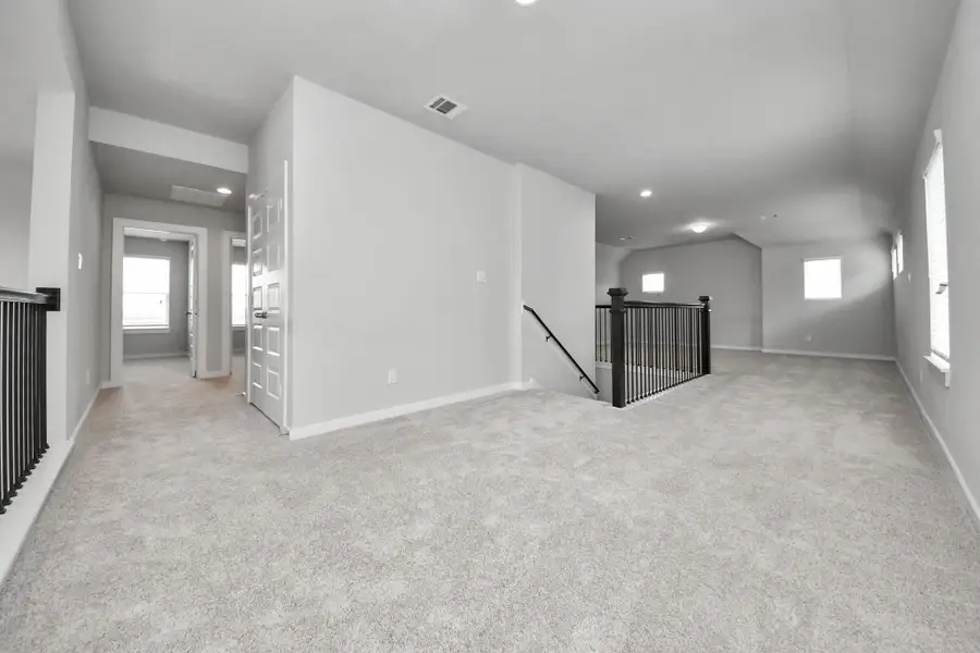 Come upstairs and enjoy a day of leisure in this fabulous game room! This is the perfect hangout spot or adult game room! Features plush carpet, high ceilings, custom paint and windows for plenty of natural light. Sample photo of completed home with similar floor plan. Actual colors and selections may vary.