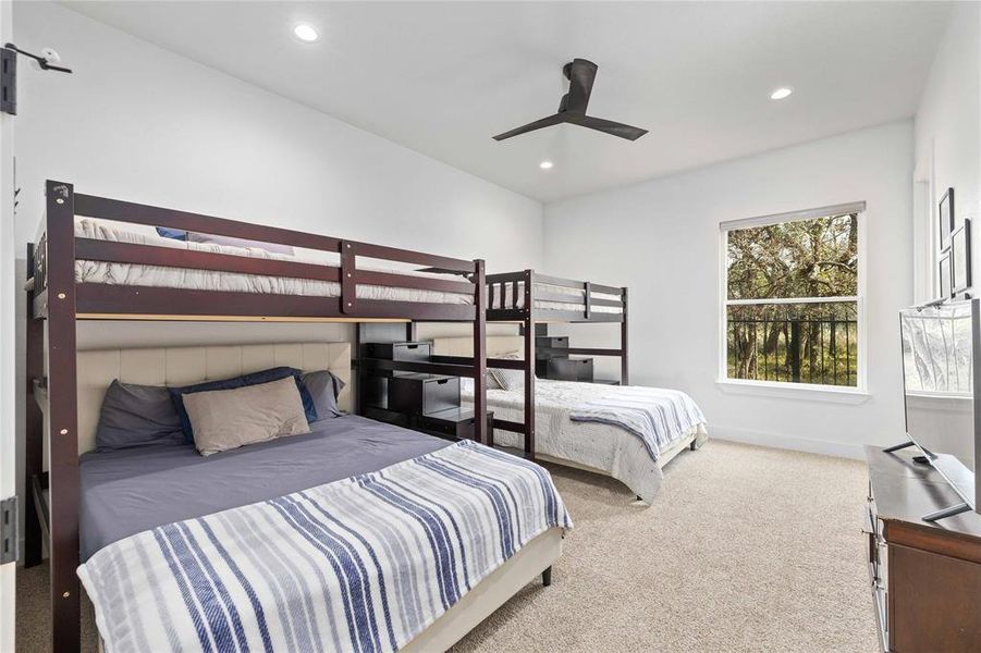 Carpeted bedroom featuring a ceiling fan and recessed lighting