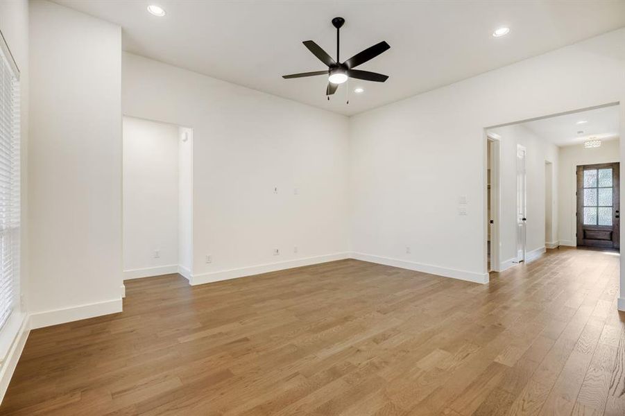 Spacious room featuring wood-finish flooring, recessed lighting, and a contemporary ceiling fan