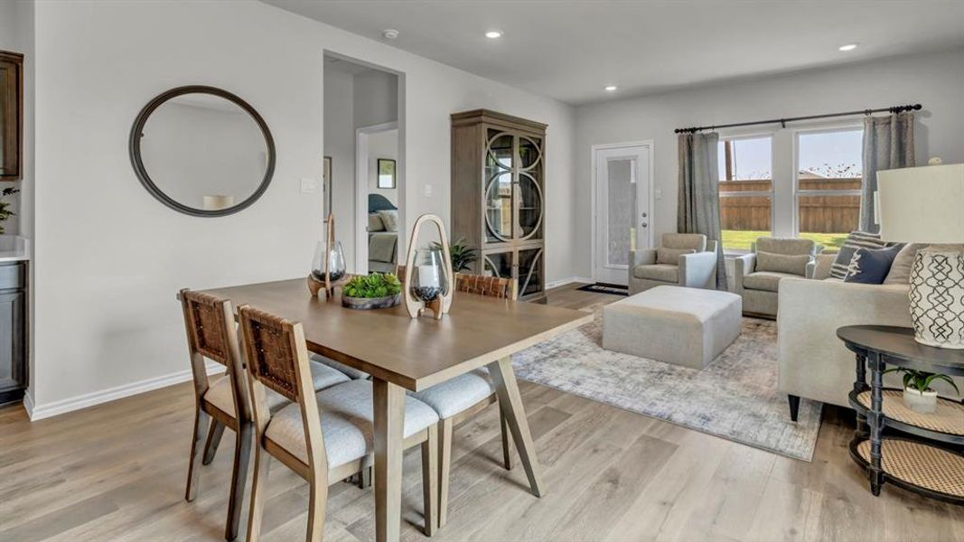 Open concept living and dining area featuring wood-finish flooring, recessed lighting, and a neutral color palette Open concept living and dining area featuring wood-finish flooring, recessed lighting, and a neutral color palette