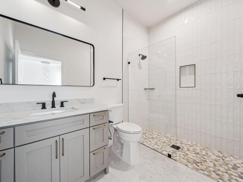 Bathroom with vanity, toilet, and a shower with shower door