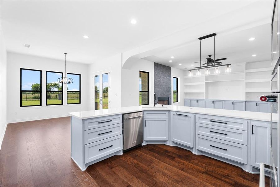 Kitchen featuring stainless steel dishwasher, a ceiling fan, light countertops, open floor plan, and recessed lighting Kitchen featuring stainless steel dishwasher, a ceiling fan, light countertops, open floor plan, and recessed lighting