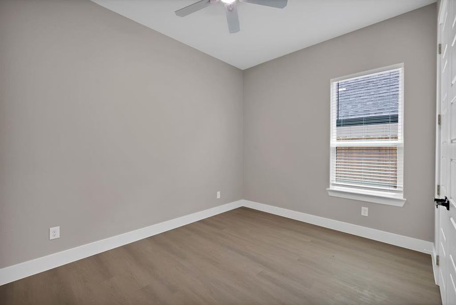 Empty room featuring ceiling fan, baseboards, and wood finished floors