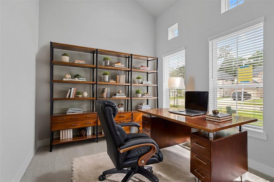 Quietly nestled in front of the home is the handsome home office. Featuring plush carpet flooring, custom paint and a large windows.