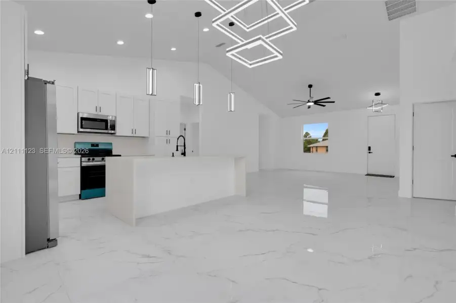 Kitchen with off-white cabinetry, stainless steel appliances, and pendant lighting over the island.